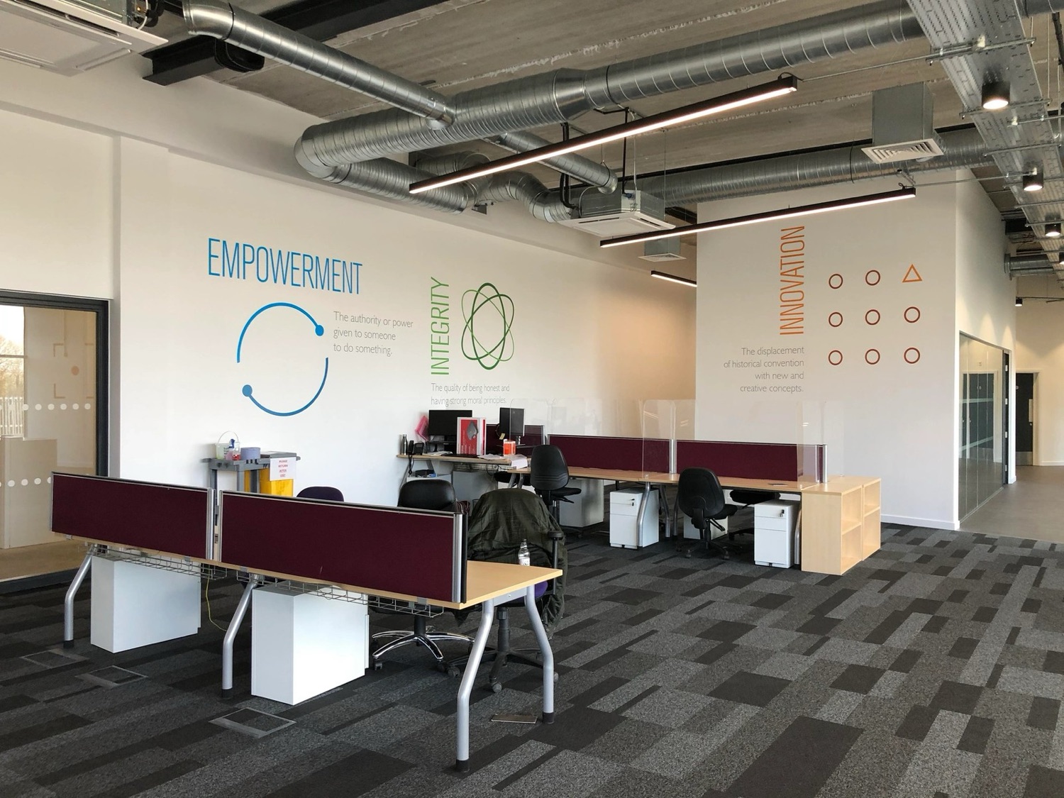 Cut-vinyl values lettering on office walls reading Empowerment, Integrity, Innovation